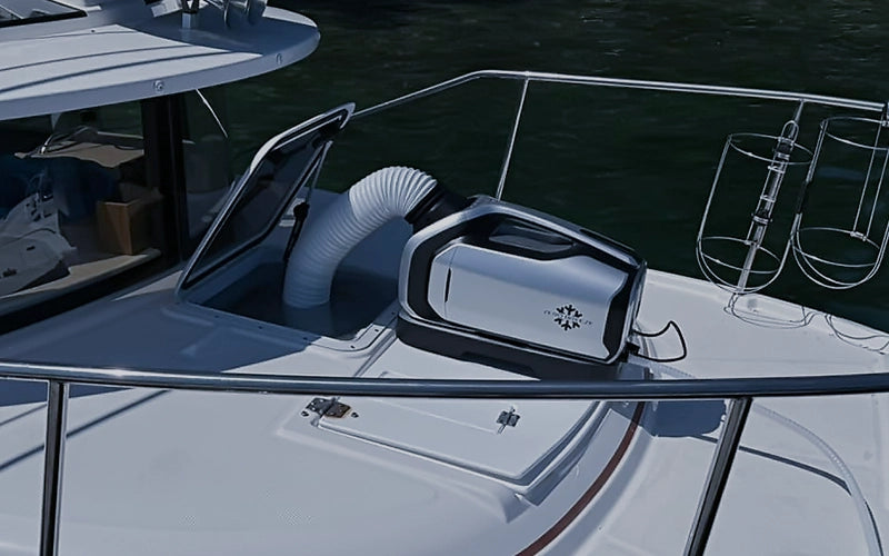 The Mark 2 portable AC is installed on a boat's deck, with its flexible duct connected to the front air outlet, providing cool air to the cabin.