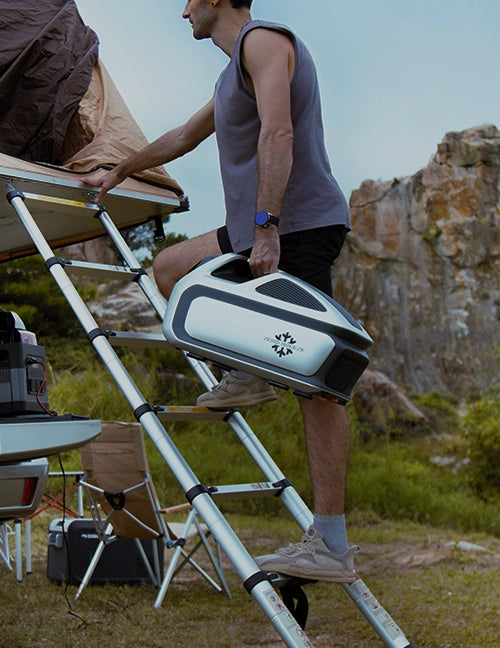 A man carries the Mark 3 in one hand while climbing a ladder to his rooftop tent.