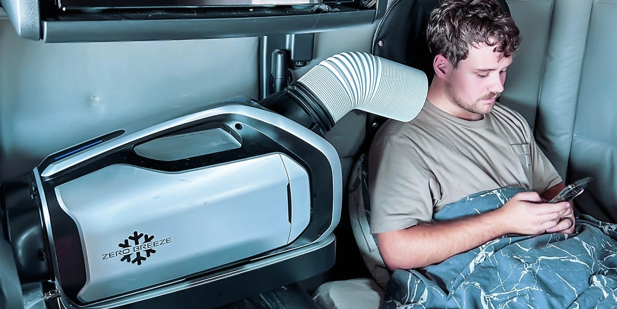 A truck driver relaxes while using the Mark 2 portable AC, directing its front air outlet duct for personal cooling.