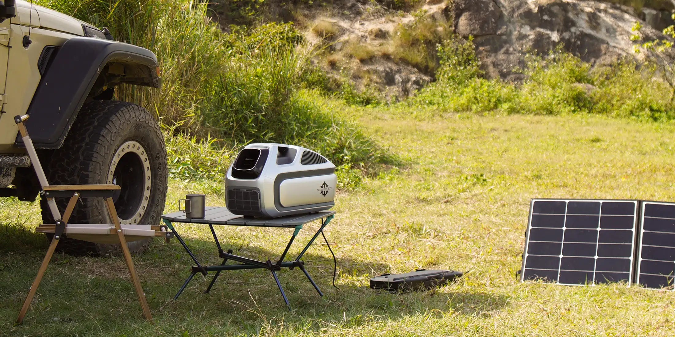 A ZERO BREEZE Mark 3 portable air conditioner is running while its battery is being recharged by solar panels, placed next to a camping chair and jeep in the background.